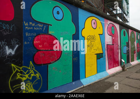 Street Art vom französischen Künstler Thierry Noir zeigt stilisierte Profil Köpfe auf der East Side Gallery, ein Überbleibsel der Berliner Mauer gemalt. Stockfoto