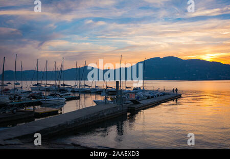 Eine Anlegestelle für Boote bei Sonnenuntergang am Ufer des Lago Maggiore in Italien Stockfoto