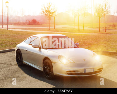 Bologna, Italien - 6. Februar 2019: Seitenansicht eines grauen turbo Sportwagen, Porsche Carrera 996 4 in einem Stadtpark mit Sonnenuntergang Licht und Fernlicht Stockfoto