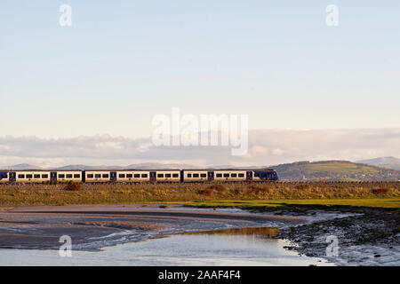 Der Zug der Northern Rail, der nach Süden fährt, hat gerade den Viadukt überquert, der die Fluss-Kent-Flussmünde bei Arnside, Cumbria, Großbritannien überspannt Stockfoto