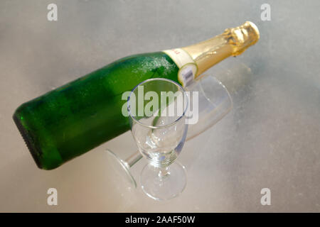 Blick von oben aus einer Tabelle, in der Es gibt zwei Gläser neben einer Flasche Sekt für eine romantische Feier für Zwei Stockfoto