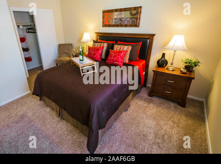 Ein Bett Tablett mit Champagner sitzt auf einem Bett im Four Seasons Apartments in Mobile, Alabama. Der Apartmentkomplex ist im Besitz von Sealy Management betrieben. Stockfoto