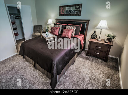 Ein Bett Tablett mit Champagner sitzt auf einem Bett im Four Seasons Apartments in Mobile, Alabama. Der Apartmentkomplex ist im Besitz von Sealy Management betrieben. Stockfoto