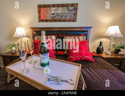 Ein Bett Tablett mit Champagner sitzt auf einem Bett im Four Seasons Apartments in Mobile, Alabama. Der Apartmentkomplex ist im Besitz von Sealy Management betrieben. Stockfoto