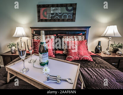 Ein Bett Tablett mit Champagner sitzt auf einem Bett im Four Seasons Apartments in Mobile, Alabama. Der Apartmentkomplex ist im Besitz von Sealy Management betrieben. Stockfoto