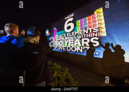 Studenten halten Handys gegen einen hellen Display an der Universität St Andrews, die die periodische Tabelle der lebt in Unterstützung der Chemie Woche kommen. Stockfoto