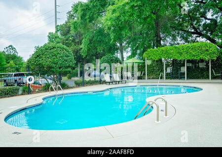 Der Pool verfügt über einen Sitzbereich im Freien mit einer Pergola auf Robinwood Apartments in Mobile, Alabama. Stockfoto