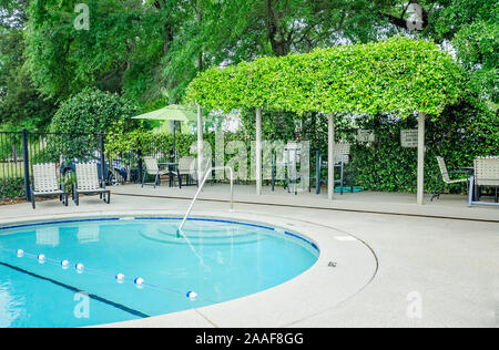 Der Pool verfügt über einen Sitzbereich im Freien mit einer Pergola auf Robinwood Apartments in Mobile, Alabama. Stockfoto