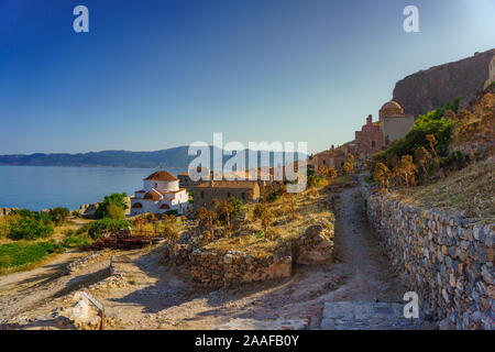 Monemvasia Kirche, alte Häuser aus rotem Backstein, Dächer in der Altstadt und dem blauen Meer, Peloponnes, Griechenland. Traditionelle griechische Architektur. Stockfoto