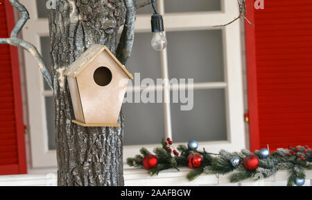 Gehängt hölzernen Vogel Haus am Baum in eingerichteten Haus Garten Stockfoto