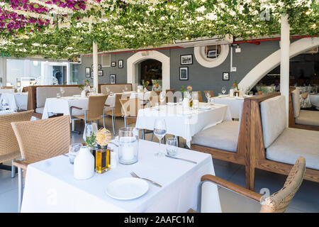 Restaurant Anordnung von Tischen und Stühlen mit weißen Tischdecken und keine Leute oder Diners an der V&A Waterfront, Kapstadt, Südafrika Stockfoto