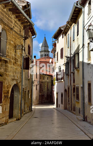 Schmale Seitenstraße (Rorno Grande) in der kleinen Stadt Vodnjan mit der Kirche von St. Blaze Glockenturm im Abstand, Istrien, Kroatien Stockfoto