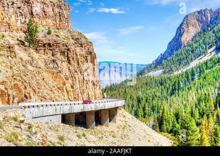 Rotes Auto auf Grand Loop Road durch Golden Gate Canyon am Kingman Pass in der nordwestlichen Region des Yellowstone National Park, Wyoming, USA. Stockfoto