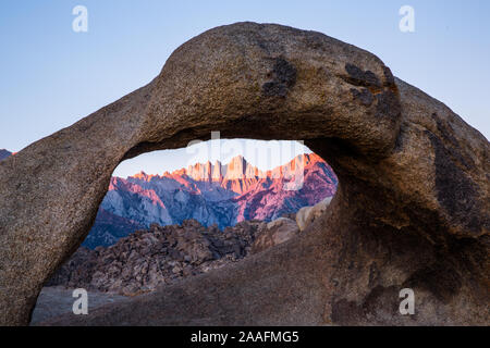 Erstes Licht des Sonnenaufgangs auf dem Mount Whitney durch Mobius Arch in den Alabama Hills suchen auf dem Weg nach Whitney Portal. Stockfoto