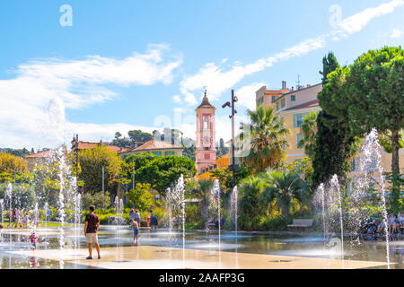 Französische Erwachsene und Kinder spielen im Wasser Brunnen Spray in den Paillon Promenade in der Stadt Nizza, Frankreich an der Französischen Riviera. Stockfoto