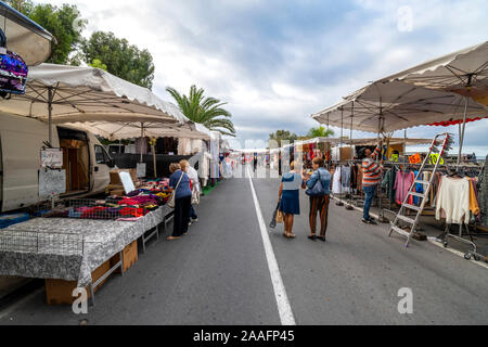 Touristen und Einheimische Italiener shop der Freitag im freien Markt mit dem Mittelmeer in Aussicht in der Stadt Ventimiglia an der italienischen Riviera. Stockfoto