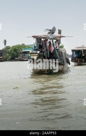 Cai, Mekong Delta, Vietnam - März 13, 2019: Entlang der Kinh 28 Kanal. Chaos auf Stern barge als Teil der schwebenden Großhandelsmarkt unter Silber Himmel. la Stockfoto