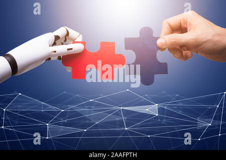 Roboter und Menschen Hand verbinden die Roten und Blauen Puzzleteile auf Technologie Hintergrund Stockfoto