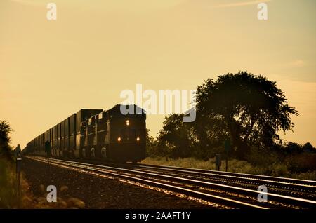 Cortland, Illinois, USA. Eine Union Pacific Güterzug nähern Cortland, Illinois kurz vor Sonnenuntergang Stockfoto