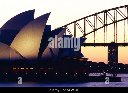 Australien. New South Wales. Sydney. Opera House und die Harbour Bridge mit Flutlicht in der Abenddämmerung. Stockfoto