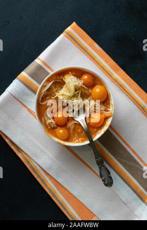 Die Schüssel mit raw-Suppe mit geschnittenen Zucchini pasta zoodles oder Nudeln und Tomaten Stockfoto