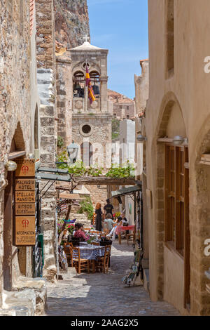 Fußgängerzone in Momenvasia, Griechenland. Schmaler Pfad führt durch Restaurants und Geschäfte mit Touristen genießen die Atmosphäre. Stockfoto