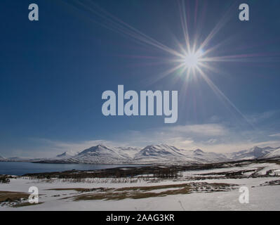 Die tiefstehende Sonne in Island mit einer wunderschönen Schneelandschaft Stockfoto