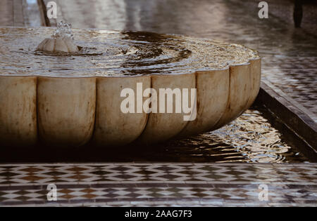 Marokkanischer Brunnen mit Wasser und Fliesenboden Stockfoto