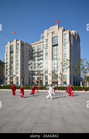 Bürger, die Tai-Chi auf einem platz vor dem Peninsula Hotel in der Nähe des Bund in Shanghai, China, vorführen. Stockfoto