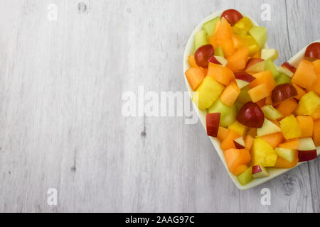 Obst Salat frisch mit Ananas, Weintrauben, Äpfel, Canteloupe und Honigmelonen. Bietet viel Platz kopieren. Stockfoto