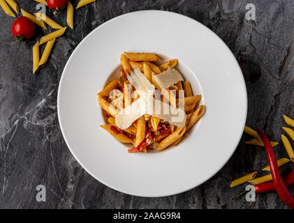 Penne Pasta mit würziger Sauce, Chili, Pfeffer und geriebenem Parmesan Stockfoto