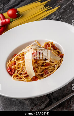 Spaghetti mit einer würzigen Sauce, Chili, Pfeffer und geriebenem Parmesan Stockfoto