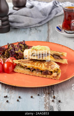 Türkische Toast mit gebratenem Fleisch mit türkischen schwarzer Tee serviert. Stockfoto
