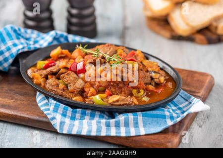 Rindfleisch Eintopf mit Kartoffeln, Möhren und Kräuter in Eisen Kasserolle, Ansicht von oben Stockfoto