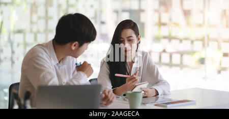 Zwei junge professionelle Grafiker ihre Idee Austausch zusammen in modernen Büro Zimmer Stockfoto