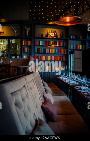 Wundervolles Restaurant in einem Loft Stil. braun Stühle, Regale mit Geschirr und Geräten. holztische Stockfoto