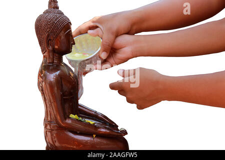 Während des Songkran-Festivals gießen Gläubige sanft duftendes, mit Blumen angereichertes Wasser auf Buddha-Statuen, wobei sie kleine Schüsseln als Zeichen der Ehrfurcht verwenden. Stockfoto