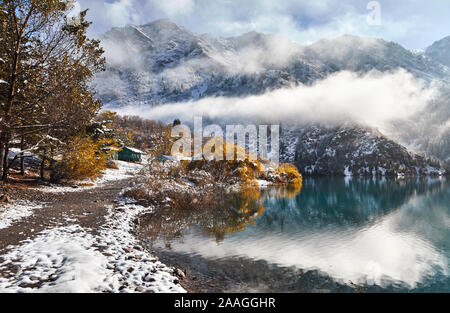 Schöne Sicht auf die Berge Issyk mit gelben Bäume im Herbst bei Schnee in Kasachstan und Zentralasien Stockfoto