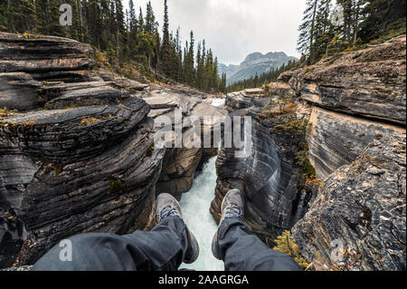 Traveler hängenden Beinen auf Mistaya Canyon Icefields Parkway in Alberta, Kanada Stockfoto