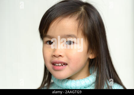 Ernsthafte hübschen kleinen asiatischen Mädchen in Blau rollkragen pullover in Nahaufnahme Kopf portrait Stockfoto