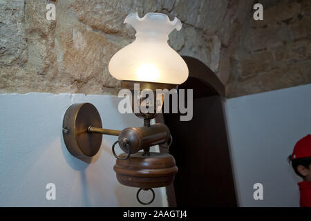 Stilvolle Lampe auf der Tapete. Wandleuchte aus vergoldetem Metall mit zwei elektrischen Kerzen. vintage Wandleuchte in Weiß mit Freistellungspfad isoliert. Warm Stockfoto