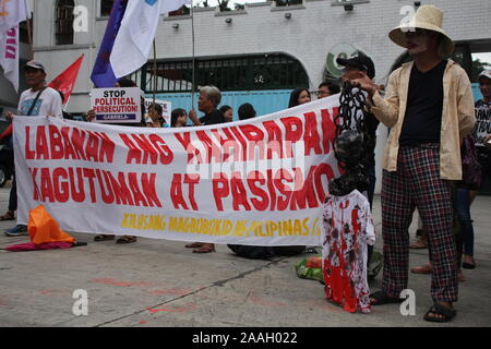 Quezon City, Philippinen. 22 Nov, 2019. Progressive Gruppen stürmte außerhalb der Abteilung der Nationalen Verteidigung (DND) in Quezon City während des ersten Jahrestages der Erklärung der Vereinbarung um 32 (MO 32). Executive Secretary Salvador Medialdea unterzeichnet Memorandum Nr. 32 auf Befehl von Präsident Rodrigo Duterte letztes Jahr für die Bereitstellung von mehr Soldaten und Polizisten der Bicol Region und in den Provinzen Samar, Negros Oriental, Negros Occidental auf uppress gesetzlose Gewalt und Terror." (Foto von Joseph Dacalanio/Pacific Press) Quelle: Pacific Press Agency/Alamy Stockfoto