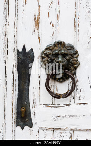 Antike Türgriff in Form eines Löwen auf eine weiße Holztür, close-up Stockfoto