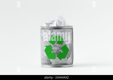 Papierkorb voll mit zerknittertem Papier mit Recycling Symbol auf weißem Hintergrund Stockfoto