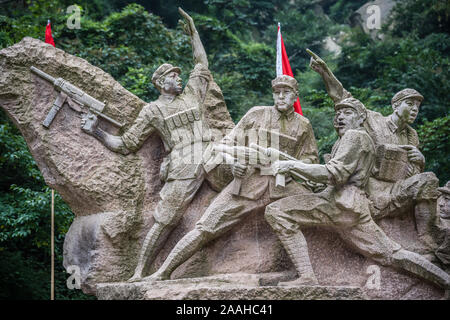 Huashan, China - August 2019: Historische Skulptur Darstellung kommunistischen Soldaten mit Waffen anb rote Fahnen am Fuße des Huashan Berg, Xian, Sh Stockfoto