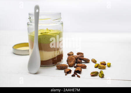 Milch cremig Dessert im Glas mit Nüssen und Schokolade Cremes auf weißem Hintergrund. Stockfoto