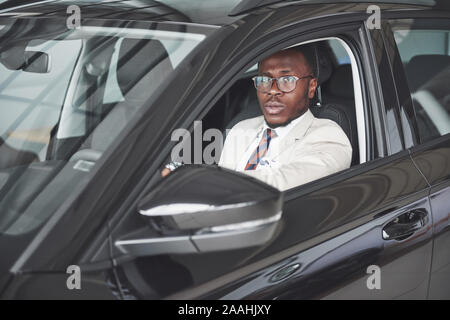Vorderansicht des Schönen afrikanischen elegante Ernst Mann fährt Auto Stockfoto