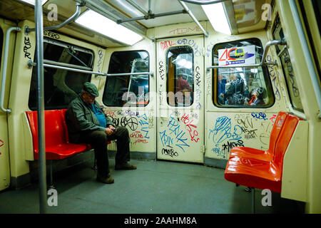 Bukarest, Rumänien - November 19, 2019: Ein Mann ist in eine schmutzige und alte U-Bahn Waggon voller Graffiti unterwegs. Stockfoto