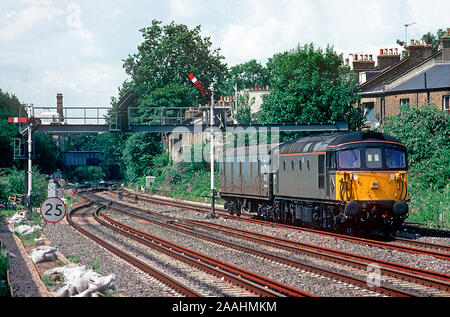 Eine Klasse 33 Crompton Diesellok Reihe 33101 Köpfe durch Kensington Olympia mit einer einzigen Mail van im Schlepptau. Stockfoto