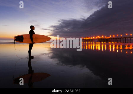 Surfer, bei Sonnenuntergang Huntington Beach, Kalifornien, USA Stockfoto